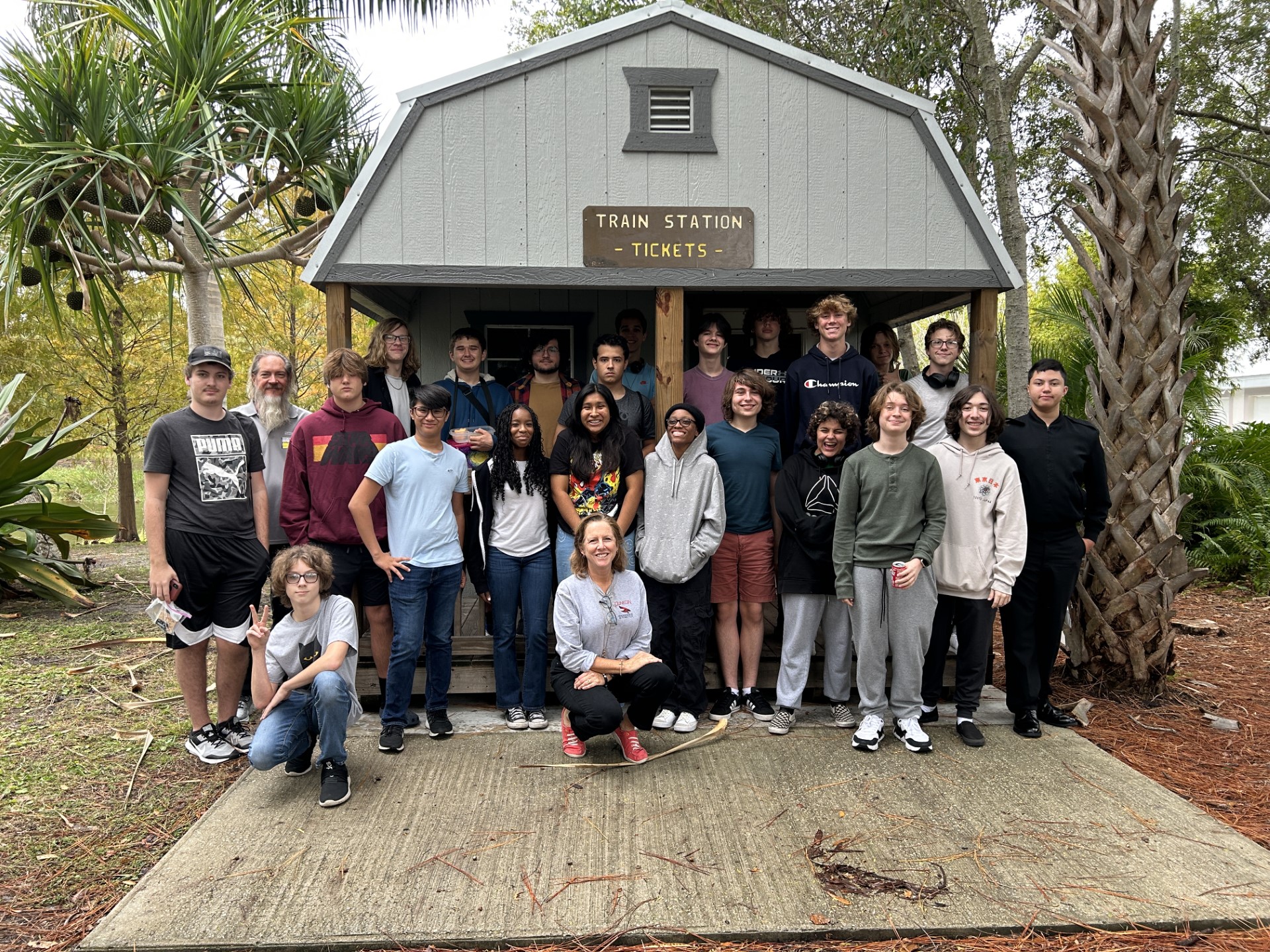 A group of people standing in front of a buildingDescription automatically generated
